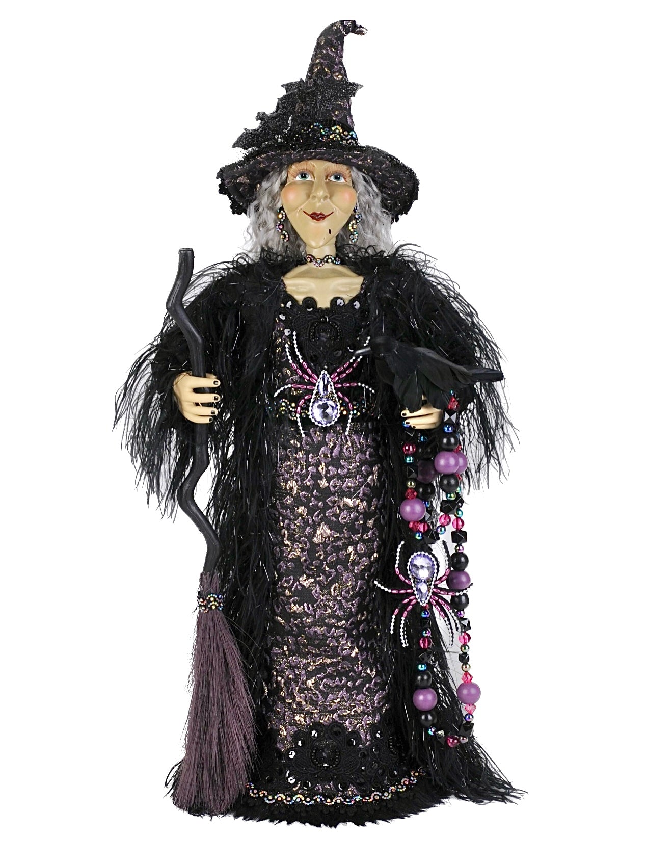 Decorative witch figurine with a broom on a white background