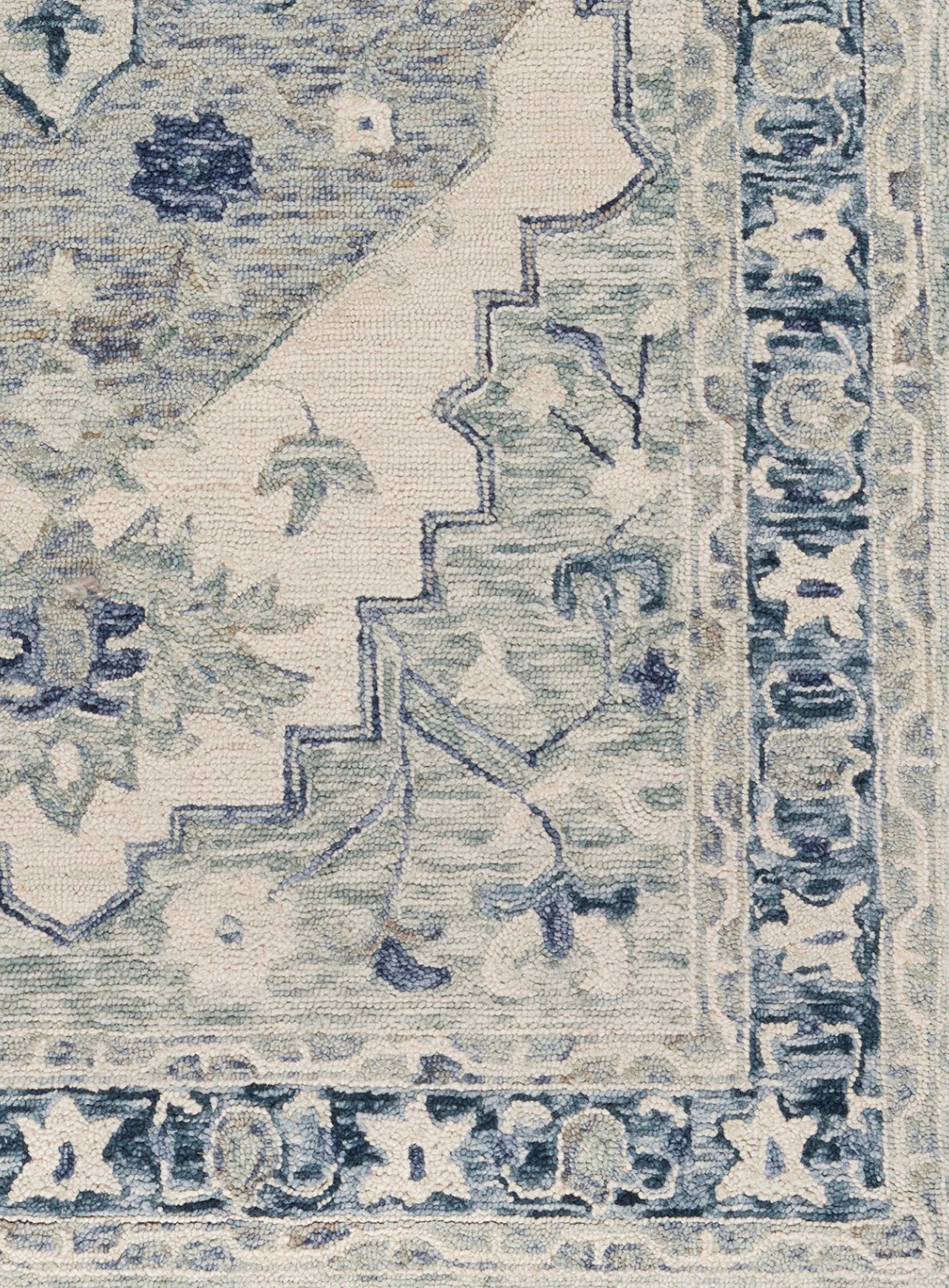 Close-up of a patterned rug with blue and beige colors