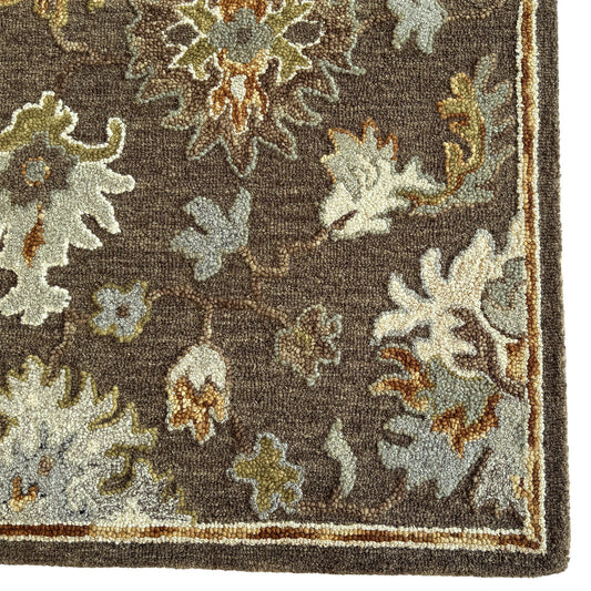 Close-up of a floral patterned rug with brown and beige colors.