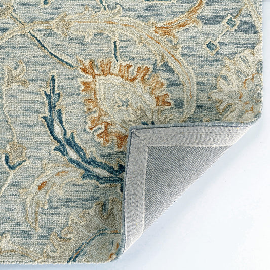 Close-up of a patterned rug corner with floral designs on a white background