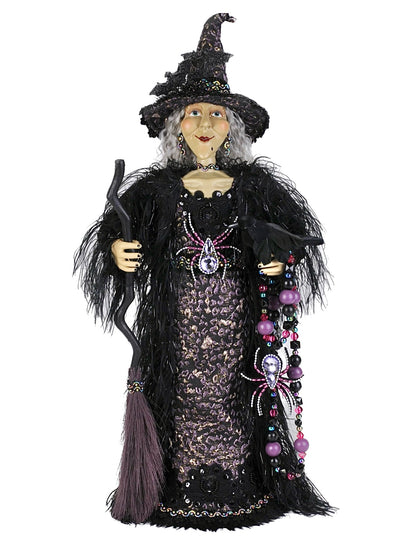 Decorative witch figurine with a broom on a white background