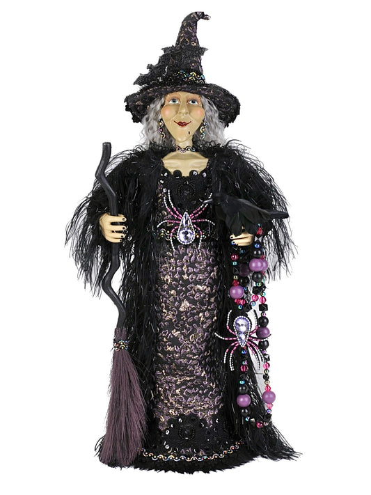 Decorative witch figurine with a broom on a white background