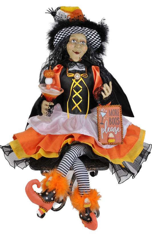 Halloween-themed doll with black hair, checkered hat, and colorful outfit on a white background