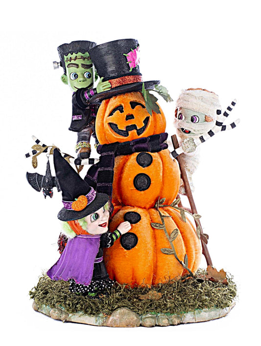 Halloween-themed decorative figure with pumpkins, witch, and mummy on a white background