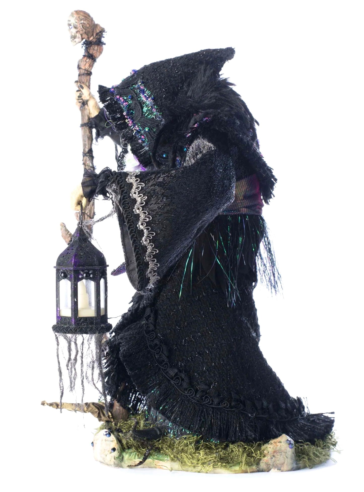 Decorative witch figurine holding a lantern on a white background