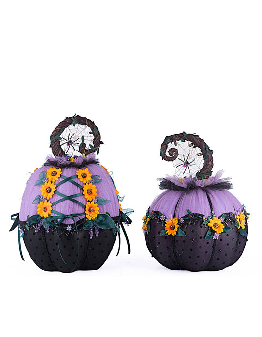 Two decorative pumpkins with purple tops, black bodies, and sunflower decorations on a white background.
