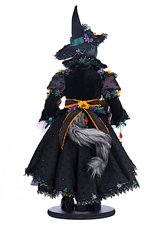 Decorative figure of a witch with a black dress and hat on a white background