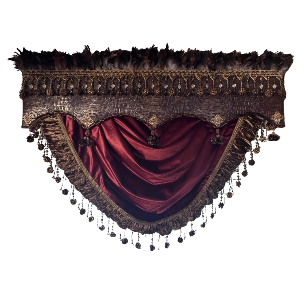 An ornate historical-style curtain valance featuring a deep burgundy satin drape, dark brown feather trim, and intricate gold and bronze embroidered detailing with hanging tassels, isolated on a white background.